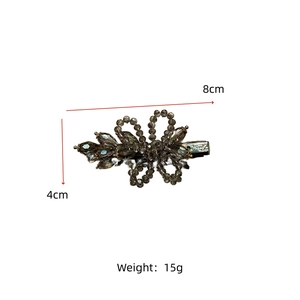 Detail view of 8cm crystal flower hair clip with grey beads on a metal base