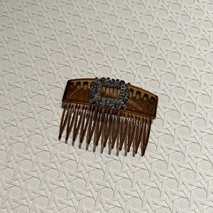 Macro detail of French vintage hair comb with silver square rhinestone buckle and brown teeth