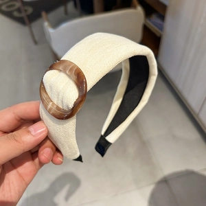 Close-up of cream corduroy headband with a brown amber buckle and black non-slip lining