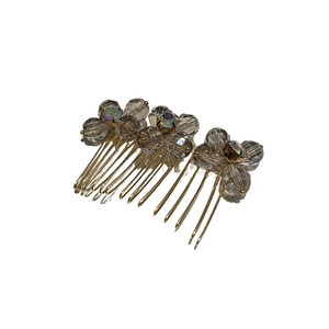 Elegant gold metal hair comb with smoky crystal beads and iridescent rhinestones in a top view