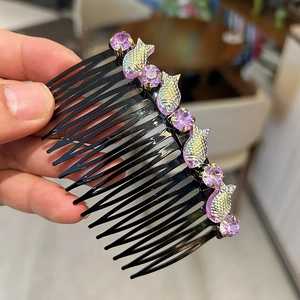 Dettaglio del pettine per capelli nero con cristalli viola e decorazioni a forma di pesce