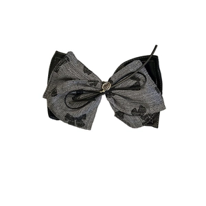 Chic grey twill bow hair accessory with black leather trim and vintage gold emblem
