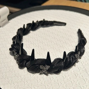 Detail of handmade black mesh headband with metallic spikes and sparkling star charms