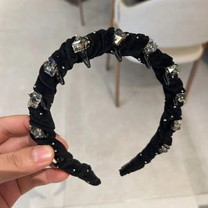 Detail of black velvet headband with smoke gray rhinestones and silver metal studs