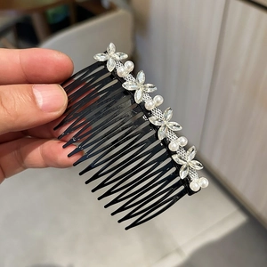 Vue macro détaillée de fleurs de trèfle en cristal et de perles blanches sur un peigne à cheveux