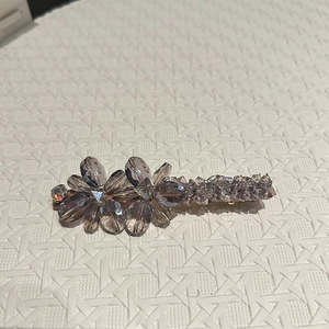 Détail de la pince à cheveux avec fleurs en cristal gris fumé et alliage doré élégant