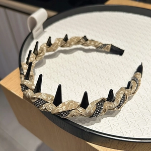 Punk style floral headband with black spikes and crystal trim on a white tray