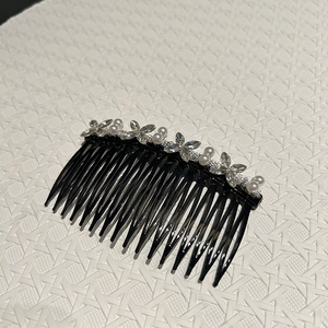 Détail du peigne à cheveux avec perles et fleurs en cristal sur base noire courbée
