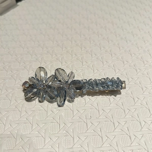 Détail d'une pince à cheveux avec fleurs en cristal bleu clair et support en métal