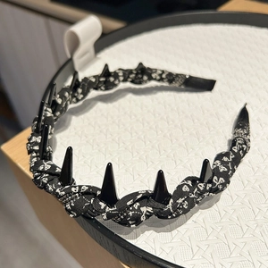 Black and white floral print headband with decorative black spikes in a punk style