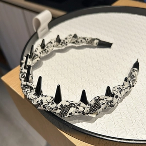Macro detail of punk floral headband featuring black glossy spikes and small bead accents