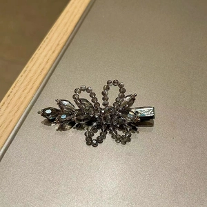 Detail view of handmade crystal flower hair clip with vintage dark grey beads and silver base