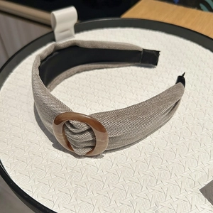 Detail of grey fabric headband with stylish amber ring buckle and soft knit texture