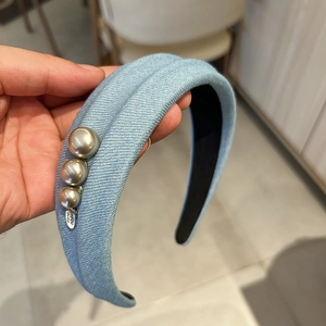 Détail du serre-tête tricoté bleu clair avec perles élégantes et étiquette artisanale