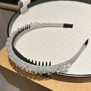 Close-up of sparkling rhinestone headband with black non-slip inner teeth and silver fabric