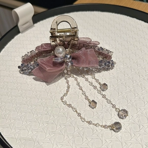 Detail of velvet mesh bow hair claw clip with dangling pearls and purple crystals