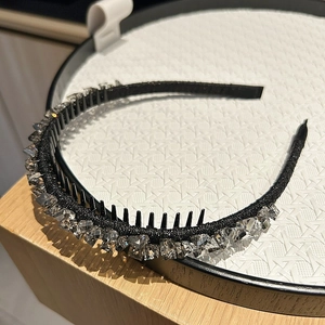Close-up of black non-slip headband with sparkling rhinestones and inner comb teeth detail