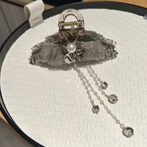 Detail of grey mesh bow hair claw clip with pearls, crystal tassels and resin finish