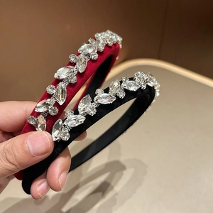 Close-up of burgundy and black velvet headbands with sparkling leaf-shaped rhinestones