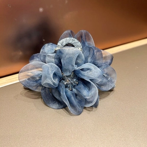 Détail de la pince à cheveux fleur en organza bleu foncé avec centre en cristal