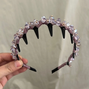 Détail d'un serre-tête en cristal violet avec des pointes noires et ornements perlés