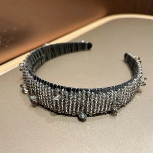 Close-up of a wide baroque headband featuring intricate crystal beading and rhinestone details