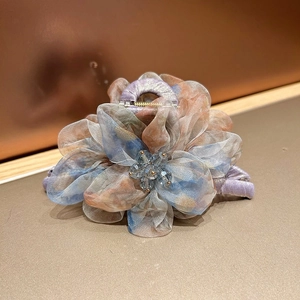 Vue détaillée de la pince à cheveux fleur en organza avec pétales colorés et perles cristal