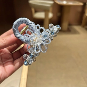 Detail of blue satin hair claw clip with handcrafted crystal flowers and beads
