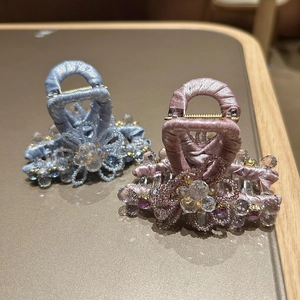 Macro detail of handmade crystal flower hair claw clips with silk wrapped handles