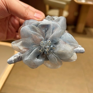 Détail de la pince à cheveux fleur en organza avec perles de cristal en bleu gris