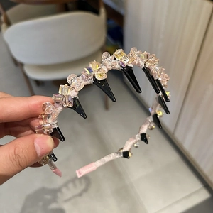 Détail du serre-tête en ruban de soie rose avec perles de cristal et peigne intérieur noir