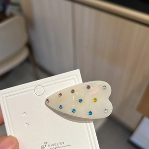 Pince à cheveux élégante en forme de cœur avec strass colorés sur carte de support