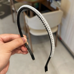 Détail rapproché de l'élégante incrustation de perles et strass argentés sur serre-tête