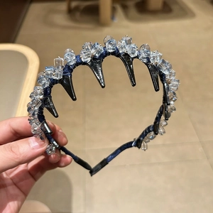 Détail du serre-tête en cristal avec tissu bleu foncé et peigne à dents noires