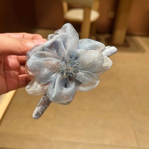 Détail de la pince à cheveux fleur en organza bleu clair avec cristal