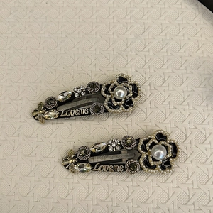 Detail of vintage camellia hair clips with pearls, crystal bee and Loveme lettering