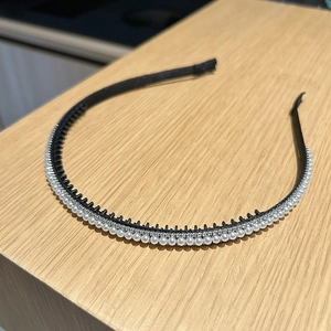 Détail de l'arguenon à double rangée avec des strass étincelants et des perles blanches