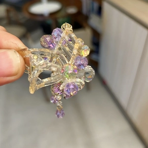Détails d'une pince à cheveux en cristal violet faite main avec deélégants glands et perles