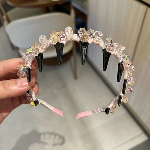 Vue détaillée du serre-tête avec cristaux colorés et satin rose avec peigne intérieur