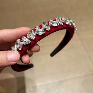 Macro shot of sparkling crystal rhinestones on a burgundy velvet headband