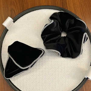 Detail of black velvet scrunchie and hair clip set with sparkling rhinestone edges
