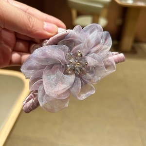 Détail de la pince à cheveux fleur en organza violet avec perles de cristal élégantes
