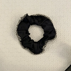 Detail of black satin scrunchie with sparkling crystal beads and elegant silk texture