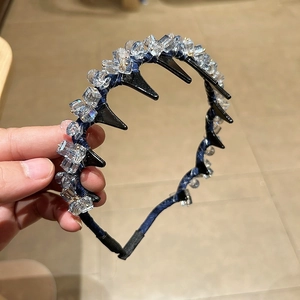Détail du peigne antidérapant noir et des perles de cristal bleu foncé sur le serre-tête