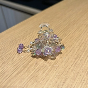 Détail d'une pince à cheveux fleur avec perles en cristal violet et pendentifs mobiles