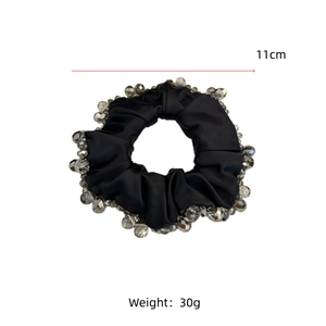 Close-up showing the 11cm diameter and 30g weight of the black crystal hair scrunchie