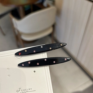 Mollette per capelli in acetato con strass colorati su una scheda per gioielli