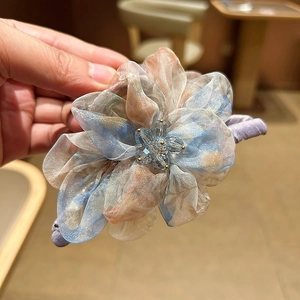 Détail de la pince à cheveux fleur en organza avec perles de cristal et dégradé de couleurs