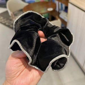 Elegant black velvet scrunchie with silver rhinestone trim for a sophisticated hair look