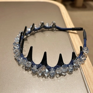 Détail d'un serre-tête de luxe gris avec perles de cristal et dents de peigne noires